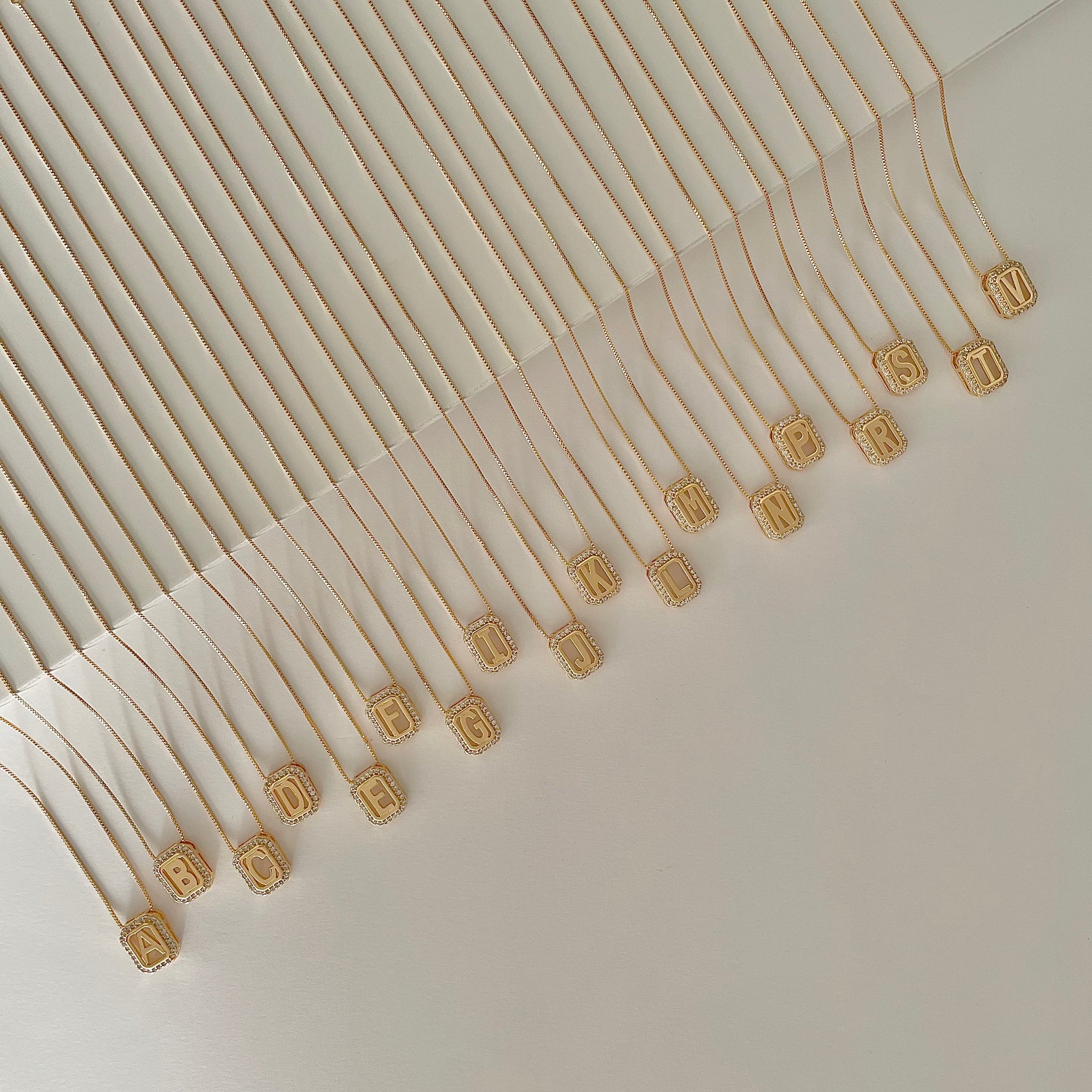 Colar letra retângulo entorno cravejado dourado