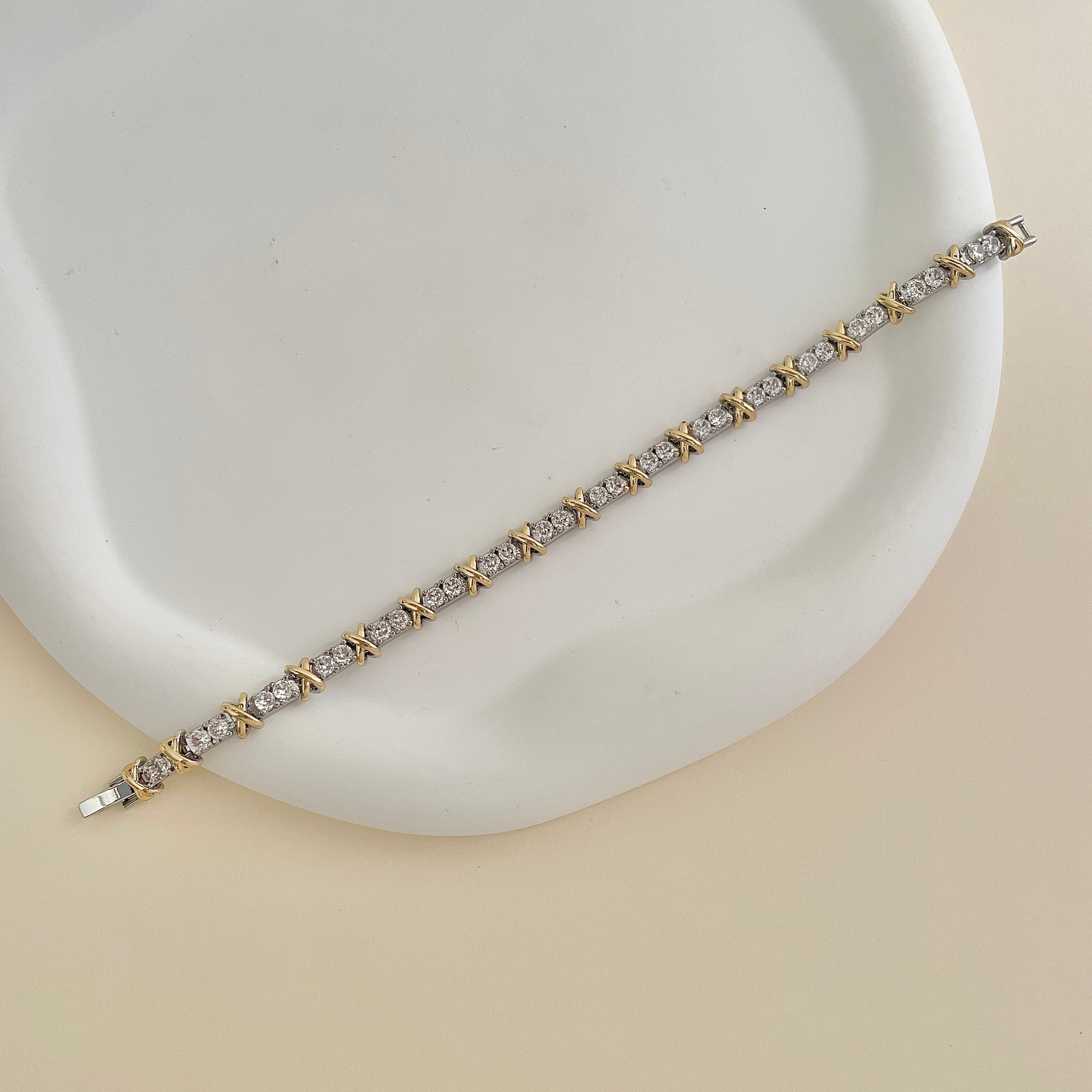 Pulseira riviera com detalhe em x dourado e banho de ródio branco tamanho 18,5cm