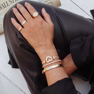 Pulseira trama com coração vazado cravejado dourado